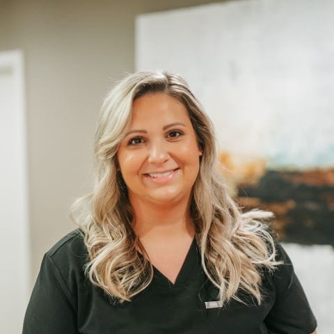 Headshot of Katie Bohac, Dental Assistant with wavy blonde hair smiles warmly in a bright dental office
