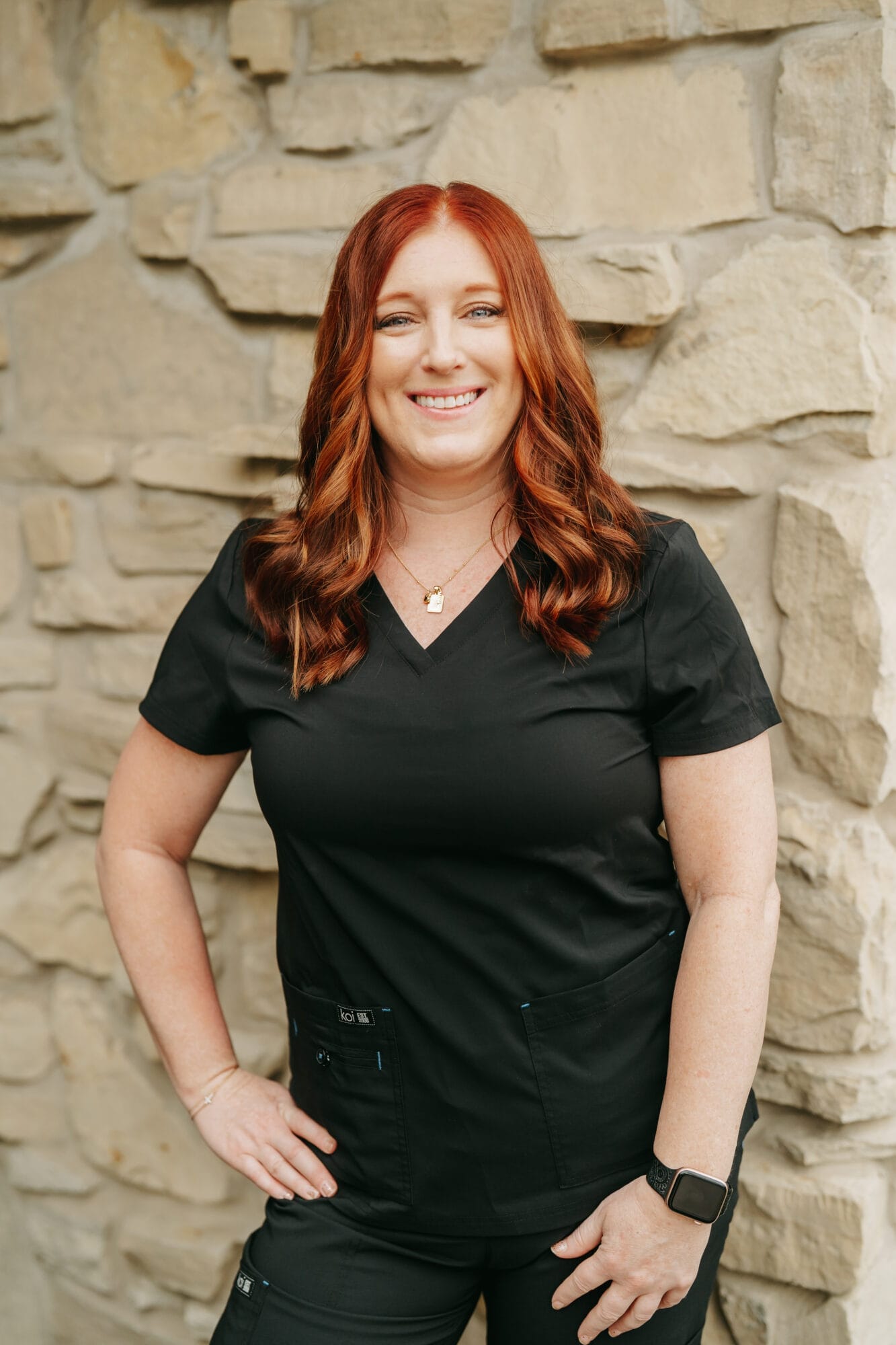 Headshot of Brooke Canady, Dental Assistant with long straight brown hair stands in a well-lit hallway of a modern dental office