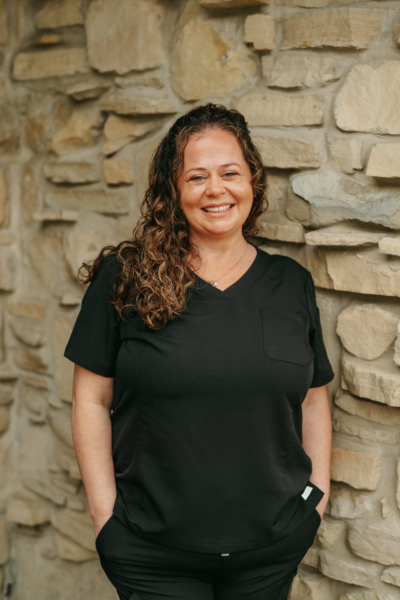 Headshot of Brooke Radtke, Hygiene Assistant with curly hair and a welcoming smile poses in a modern dental office