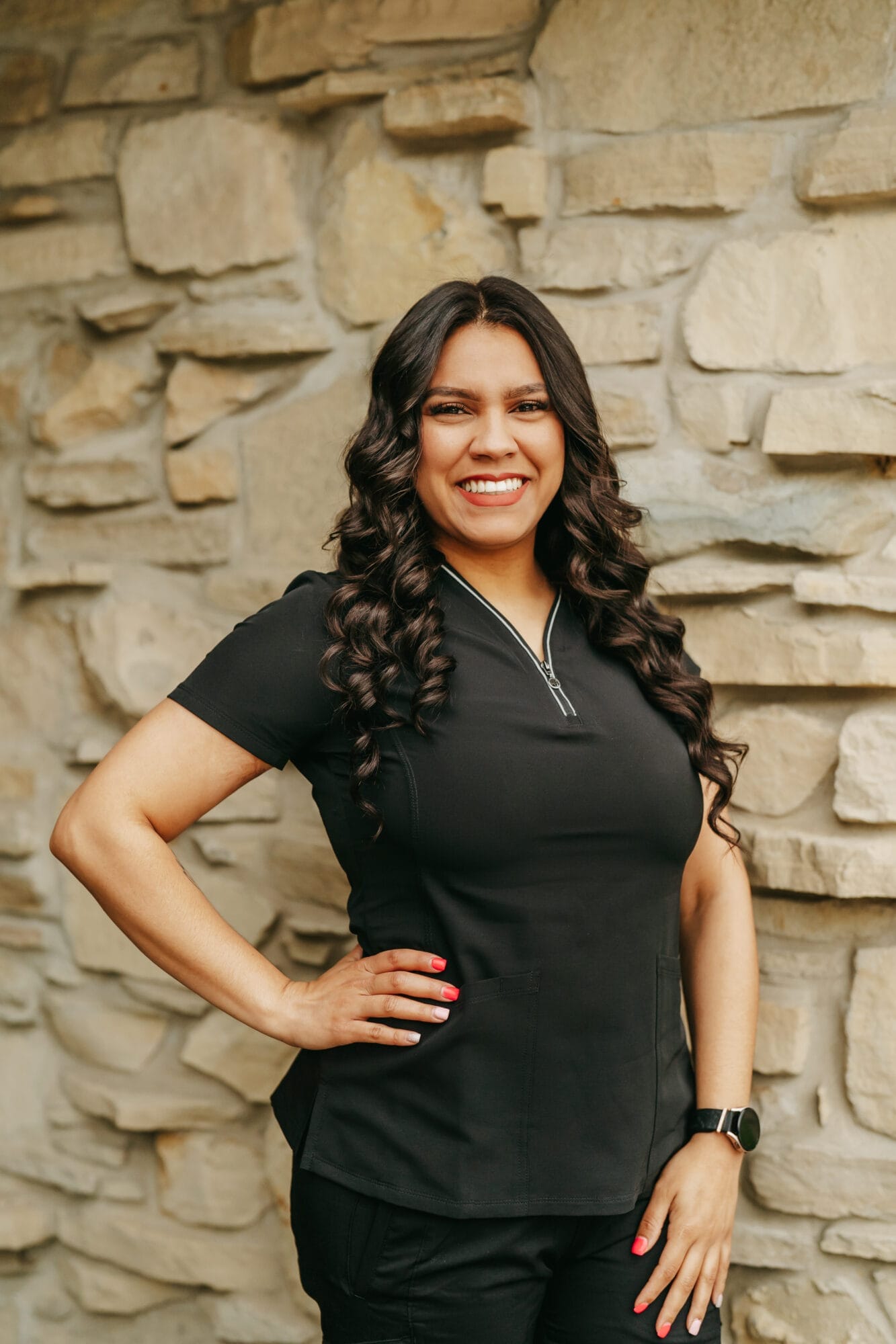 Headshot of Gelieliz Perez-Morales, Dental Assistant with long straight hair smiles brightly in a dental clinic hallway