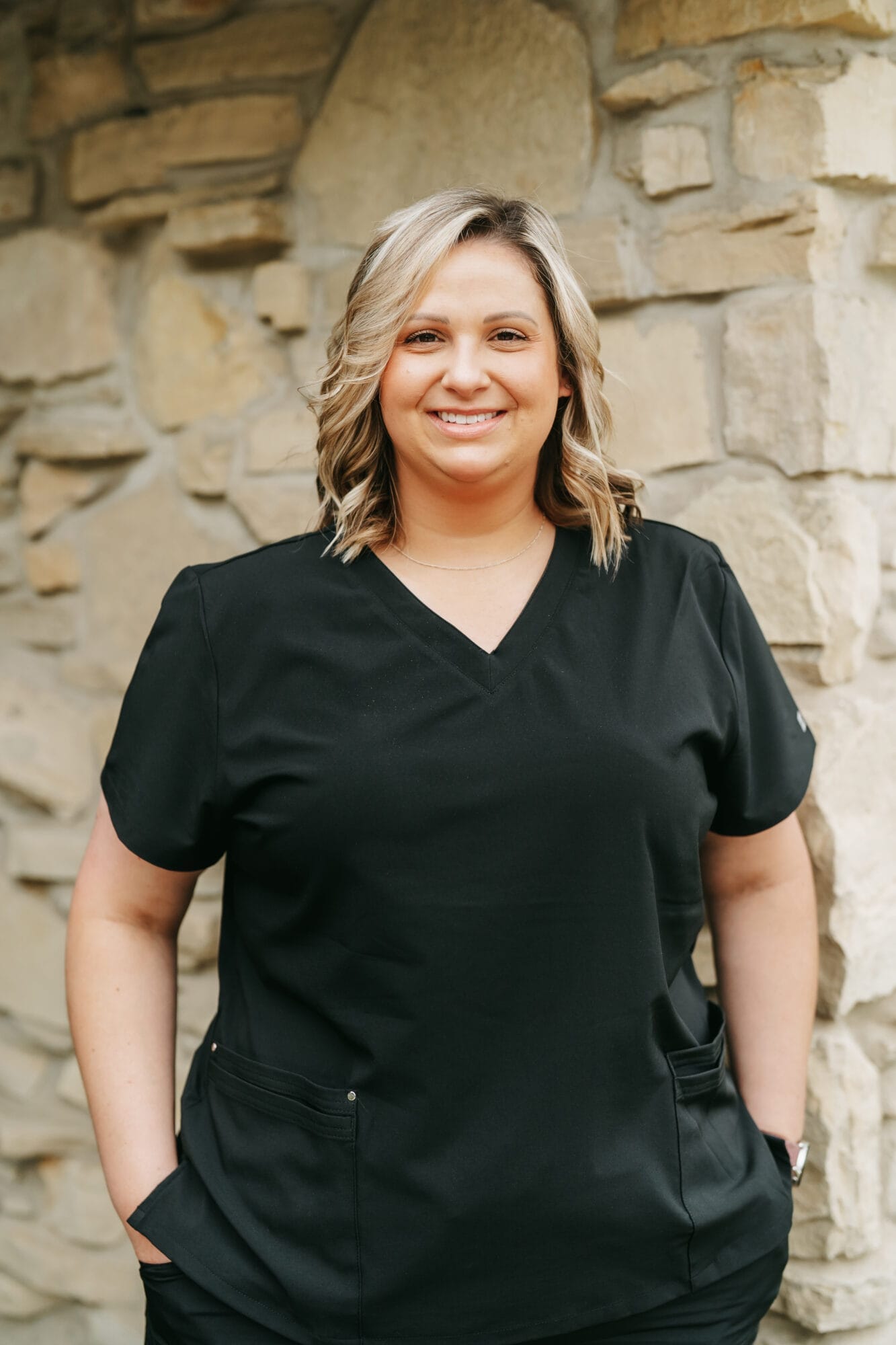 Headshot of Katie Bohac, Dental Assistant with wavy blonde hair smiles warmly in a bright dental office
